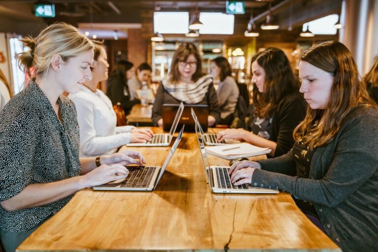 women-on-laptops-around-table